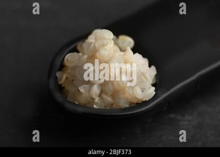 Cuillère de mesure avec grains de quinoa blanc, bouillis et spotés, closeup Banque D'Images