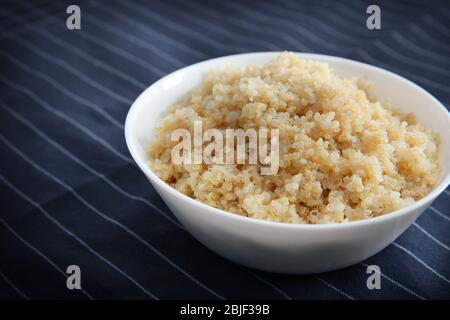 Bol en céramique avec grains de quinoa blanc, bouillis et cuits, bougeée Banque D'Images