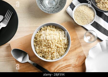 Bol en céramique avec grains de quinoa blanc et biologique bouillis sur table en bois de cuisine Banque D'Images