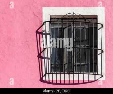 Façade rose avec fenêtre et décoration en fonte, Puebla, Mexique. Banque D'Images