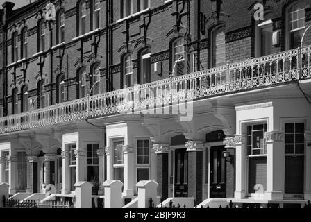 Maisons en terrasse victorienne colorées, maisons en rangée, briques rouges, style classique traditionnel de la rue sur Avenmore Road, West Kensington, Londres W14 Banque D'Images