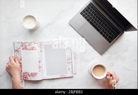 Vue de dessus en bas femme tapant sur un ordinateur portable avec une tasse à café. Banque D'Images