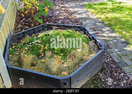 Faire du compost dans la poubelle de compostage dans un petit jardin Banque D'Images