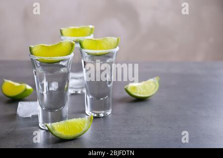 Tequila se donne avec des tranches de citron vert et du sel sur la table Banque D'Images