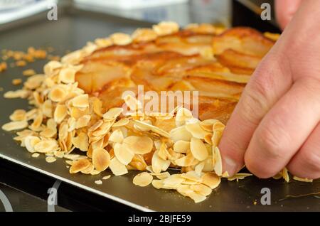 Chef main caramélisé amandes poire tarte cuisine française Banque D'Images