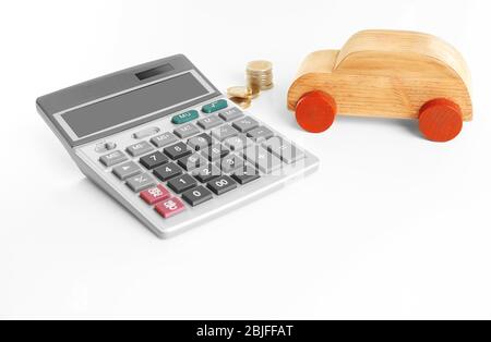 Calculatrice avec pièces et jouet sur fond blanc. Concept d'assurance automobile Banque D'Images