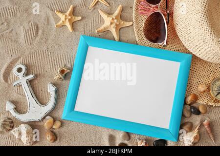 Concept de voyage. Composition des symboles marins et cadre photo vierge sur fond de sable Banque D'Images