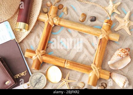 Concept de voyage. Composition des symboles marins et du cadre en bambou sur fond de sable Banque D'Images