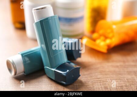Inhalateurs d'asthme avec médicaments sur table en bois Banque D'Images