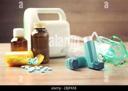 Inhalateurs d'asthme, médicaments et nébuliseur sur table en bois Banque D'Images