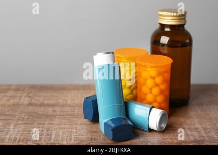 Inhalateurs d'asthme avec médicaments sur table en bois Banque D'Images
