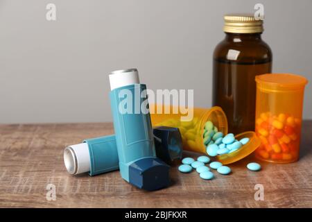 Inhalateurs d'asthme avec médicaments sur table en bois Banque D'Images