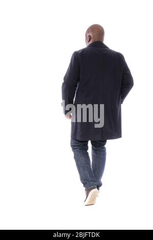 Silhouette masculine pleine de corps de retour à la vue caméra de l'homme d'Afrique américain portant un trench bleu marine avec un Jean denim bleu et des chaussures marron décontractées Banque D'Images
