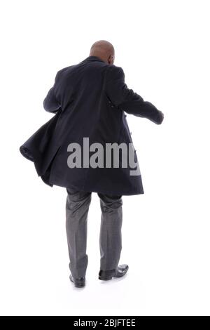 Corps entier figure masculine de retour à la vue caméra de l'homme d'affaires africain américain portant un trench bleu marine avec pantalon de costume gris formel et chaussures noires Banque D'Images
