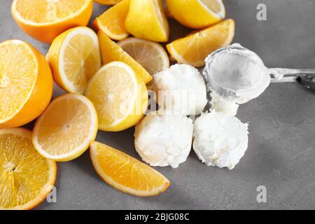 Délicieux boules de glace aux agrumes avec citrons et oranges sur fond gris Banque D'Images