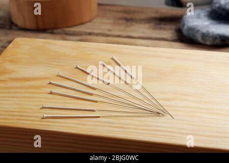 Aiguilles d'acupuncture sur planche en bois Banque D'Images