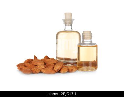 Bouteilles de parfum et amandes sur fond blanc Banque D'Images