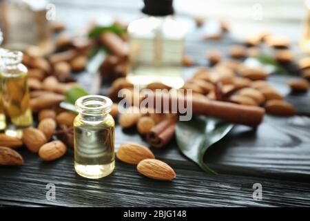 Bouteille de parfum et amandes sur table en bois Banque D'Images