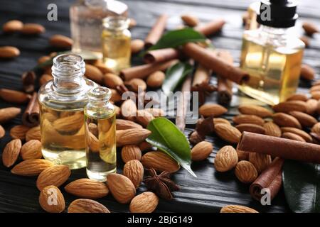 Belle composition avec des bouteilles de parfum et des amandes sur fond en bois Banque D'Images