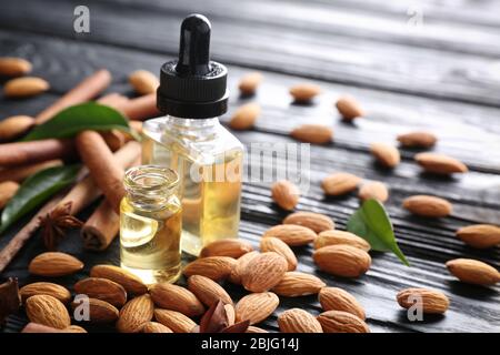 Bouteilles de parfum et amandes sur table en bois Banque D'Images