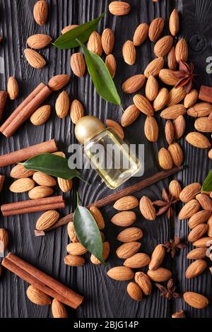 Belle composition avec bouteille de parfum et amandes sur fond en bois Banque D'Images