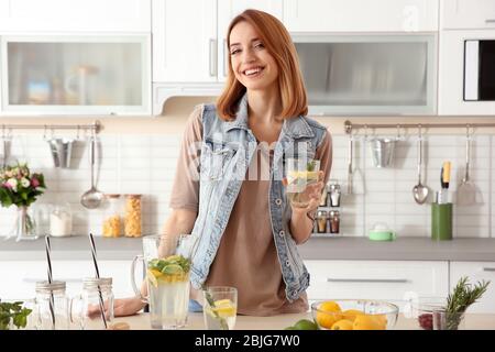 Belle jeune femme avec limonade dans la cuisine Banque D'Images