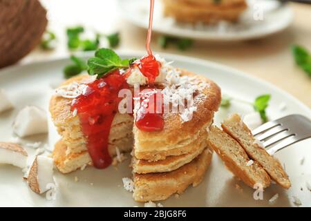 Crêpes maison savoureuses à la noix de coco avec sauce aux baies sur plaque Banque D'Images
