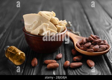 Composition avec beurre de cacao et haricots sur fond de bois Banque D'Images