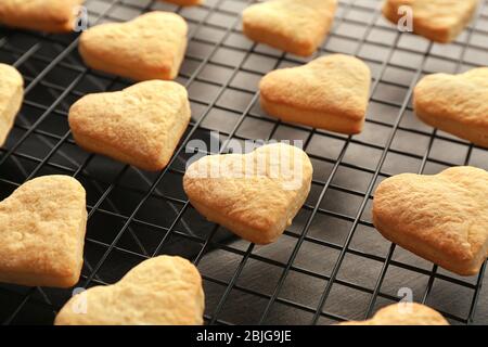 Grille de cuisson avec biscuits au beurre en forme de coeur sur table Banque D'Images