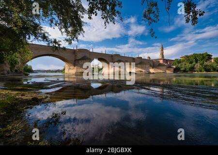 Ancien pont en pierre sur la rivière Ebro avec la tour de l'église de la cathédrale la Seo, alias Catedral del Salvador en arrière-plan, Saragosse, Espagne Banque D'Images