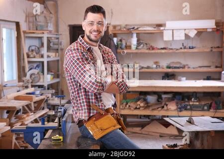 Un jeune menuisier souriant en atelier Banque D'Images