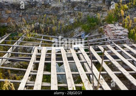 Un chat tabby errant dort sur des planches en bois couvrant l'ancien fort à l'intérieur du complexe du château de Buda à Budapest, en Hongrie Banque D'Images