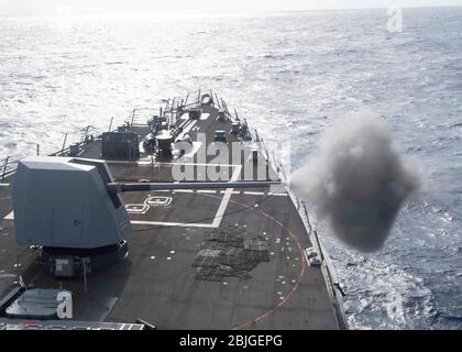 MER DES PHILIPPINES (avril. 25, 2020) le destroyer USS Mustin (DDG 89) de missile guidé Arleigh Burke déclenche un pistolet Mark 45 de 5 pouces lors d'un exercice de tir en direct. Mustin mène actuellement des opérations en soutien à la sécurité et à la stabilité dans l’Indo-Pacifique, tout en étant affecté à l’Escadron Destroyer (DESRON) 15, le plus grand DESRON déployé à l’avenir de la Marine et la principale force de surface de la 7ème flotte américaine. (ÉTATS-UNIS Photo marine par Mass Communication Specialist 3ème classe Cody Beam) Banque D'Images