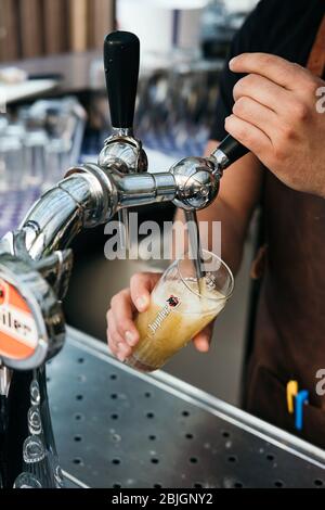 Barman versant un verre de bière pression d'un robinet. Vue rapprochée. Mains de barman verser la bière lager. Robinet à bière. Boisson alcoolisée. Banque D'Images