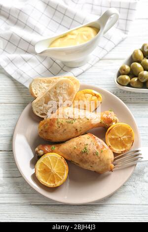 Délicieux morceaux de poulet avec citron sur la plaque Banque D'Images