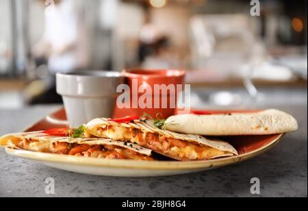 Délicieux quesadillas avec sauces sur plaque Banque D'Images