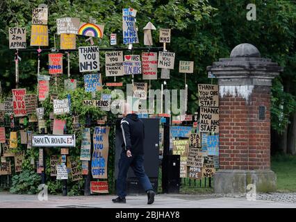 Londres, Grande-Bretagne. 29 avril 2020. Un homme passe devant un affichage de signes conçus par l'artiste local Peter Liversidge à l'appui du National Health Service (NHS) à Londres, en Grande-Bretagne, le 29 avril 2020. Crédit: Han Yan/Xinhua/Alay Live News Banque D'Images