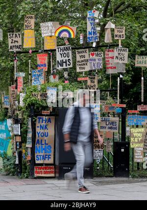 Londres, Grande-Bretagne. 29 avril 2020. Un homme passe devant un affichage de signes conçus par l'artiste local Peter Liversidge à l'appui du National Health Service (NHS) à Londres, en Grande-Bretagne, le 29 avril 2020. Crédit: Han Yan/Xinhua/Alay Live News Banque D'Images