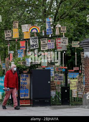 Londres, Grande-Bretagne. 29 avril 2020. Un homme passe devant un affichage de signes conçus par l'artiste local Peter Liversidge à l'appui du National Health Service (NHS) à Londres, en Grande-Bretagne, le 29 avril 2020. Crédit: Han Yan/Xinhua/Alay Live News Banque D'Images