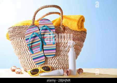 Composition avec accessoires de plage sur sable sur fond de couleur. Concept de vacances d'été Banque D'Images