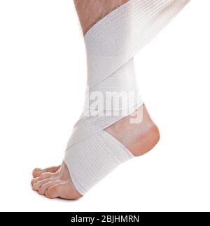 Appliquer le bandage sur la jambe du jeune homme, sur fond blanc Banque D'Images