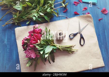 Lieu de travail de fleuriste avec de belles pivoines et accessoires dans le magasin de fleurs Banque D'Images