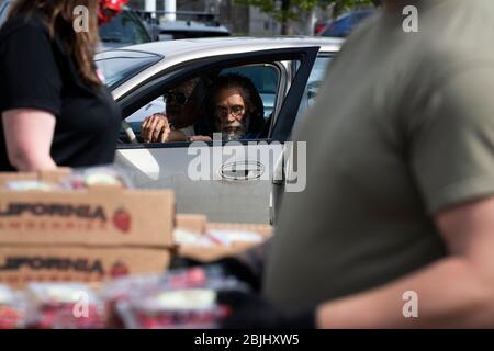 Un homme attend en ligne que les employés de la clinique des travailleurs agricoles de la vallée de Yakima et les soldats de la Garde nationale de Washington distribuent des boîtes de nourriture libre à resi Banque D'Images