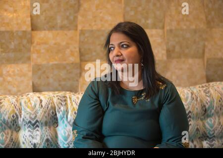 Portrait d'une femme assise sur le canapé perdu dans ses pensées. Banque D'Images