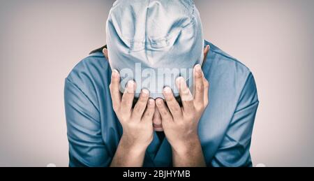 Médecin de l'hôpital pendant COVID-19 qui a besoin d'aide. Les travailleurs de la santé désespérés par rapport aux besoins d'urgence en EPI et en détresse. Coronavirus crise de mort, de dispaire, d'anxiété de santé mentale. Banque D'Images