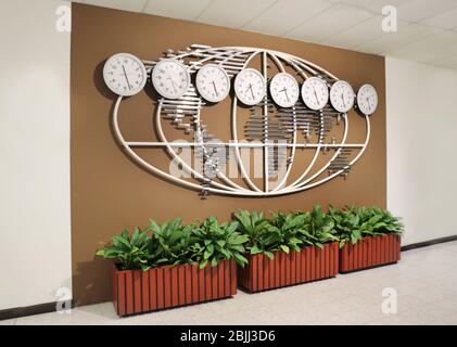 Mur avec carte du monde et horloges montrant l'heure dans différentes villes Banque D'Images