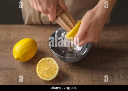 Homme extrait le jus de citron avec un alésoir d'agrumes en bois Banque D'Images