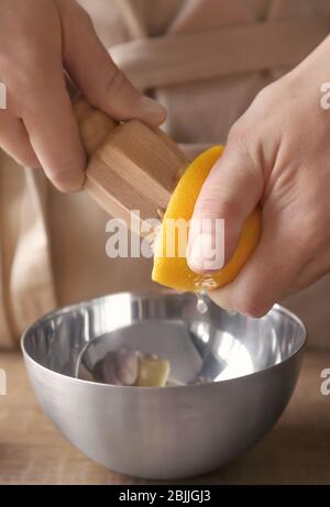 Homme extrait le jus de citron avec un alésoir d'agrumes en bois Banque D'Images