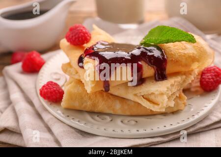 De délicieuses crêpes avec de la confiture de framboises sur la table Banque D'Images