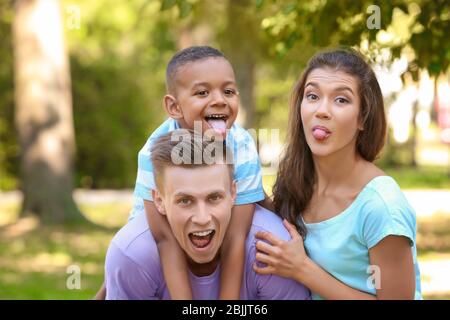 Jeune famille avec adopté africain américain garçon ayant plaisir à l'extérieur Banque D'Images